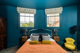 Blue bedroom with orange cover and blue pillows