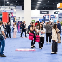 Attendees walking the busy exhibition floor at SBC Summit Americas gaming industry conference in Fort Lauderdale